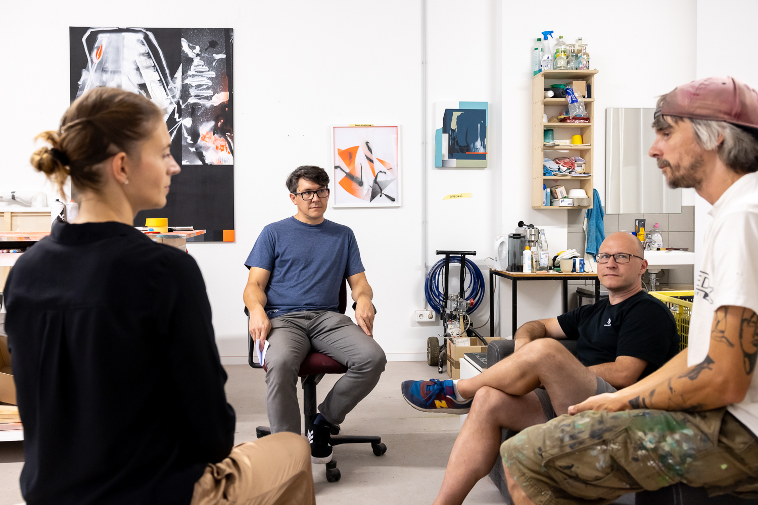 Wir sehen die Graffitikünstler Kai „Semor“ Niederhausen und Alexander Gnida sowie Yvonne Hanke und Willi Koenen von go.Rheinland im Atelier sitzen und reden.