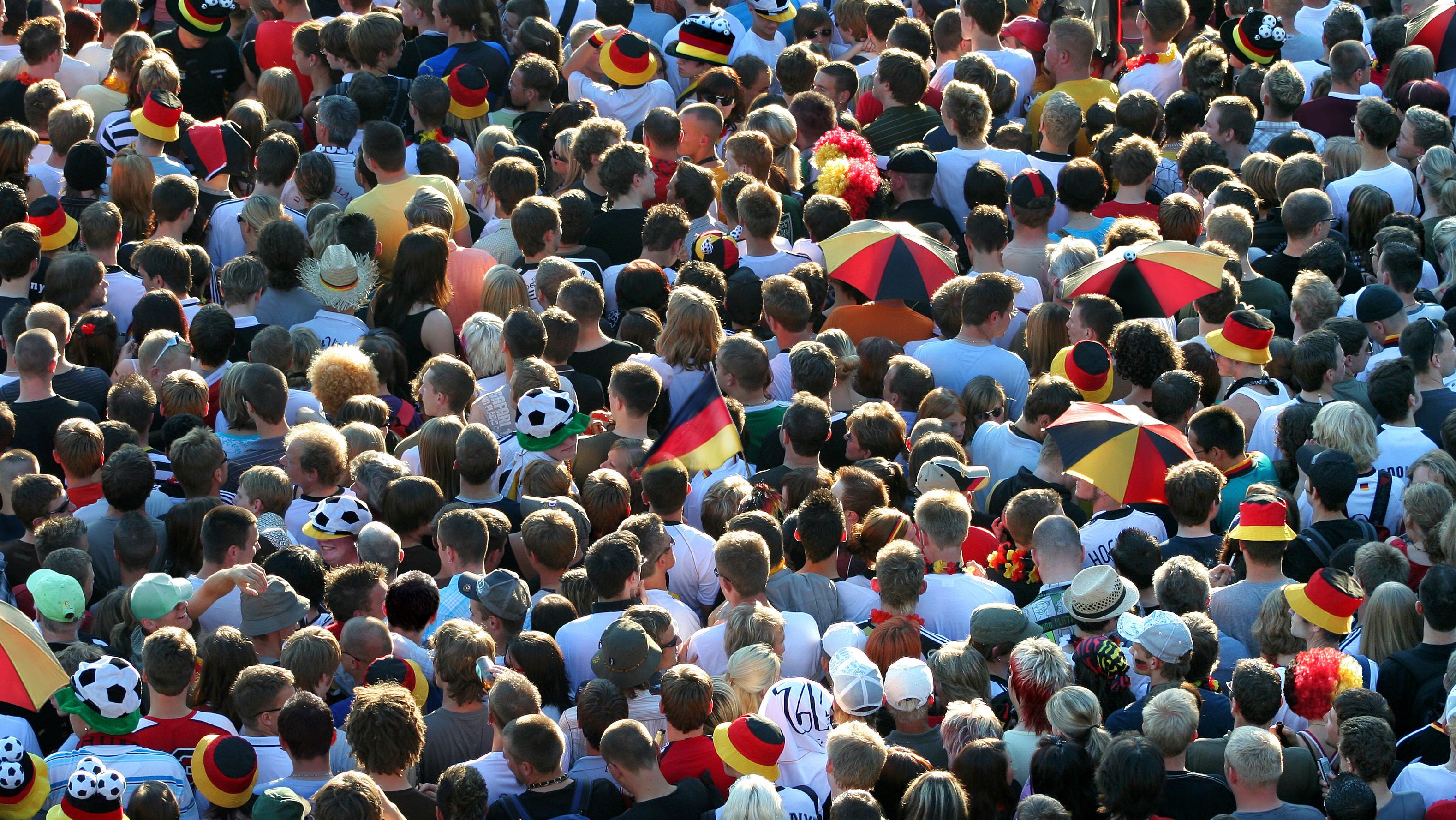 Wir sehen viele dichtgedrängt stehende Fußballfans der deutschen Nationalmannschaft.