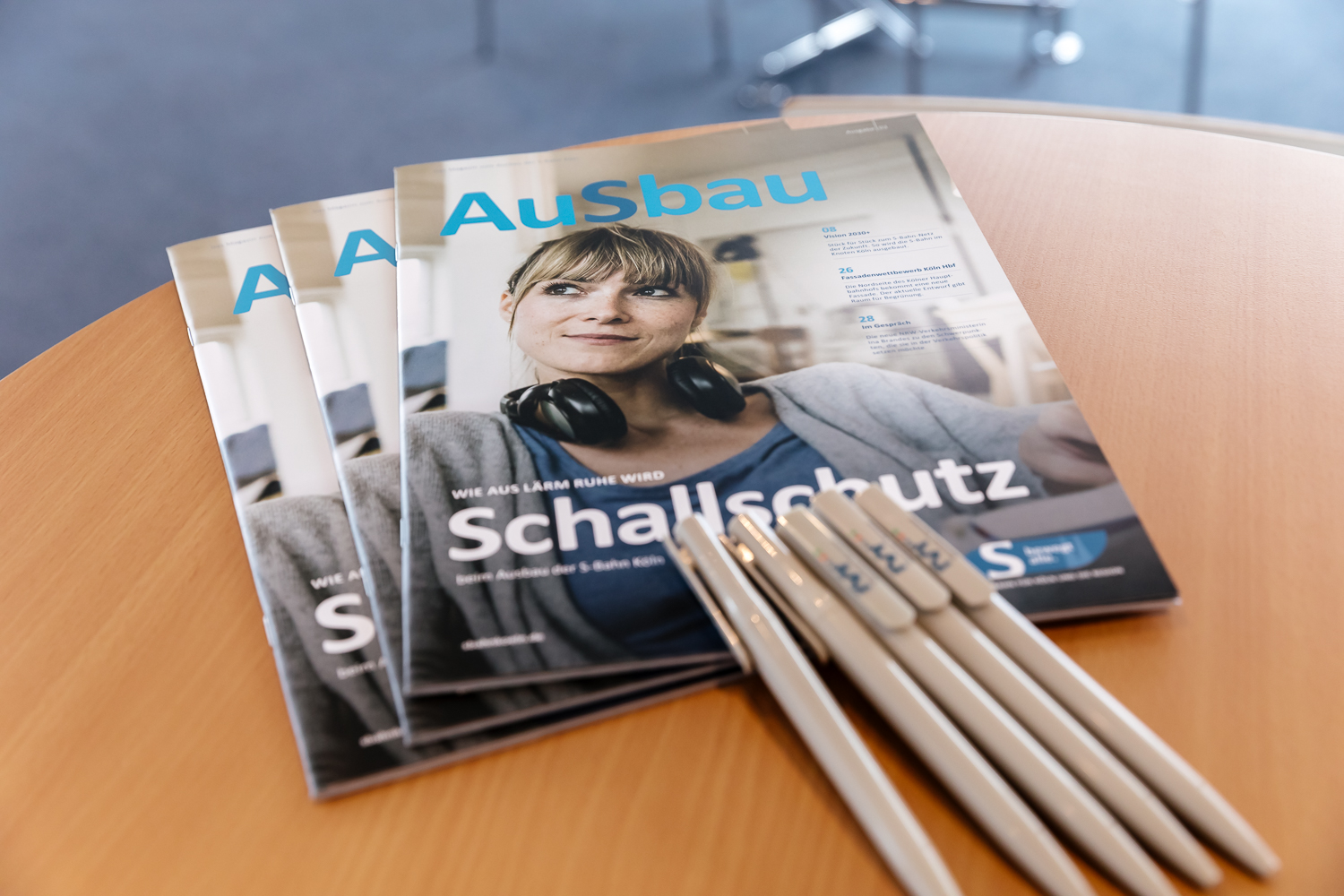 Auf einem Tisch liegen mehrere Ausgaben des Magazins „AuSbau“